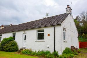 una casa blanca con techo negro en Kelpies Cottage en Newton Stewart