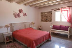 a bedroom with a bed and a bench and a window at Ergina Summer Resort in Antiparos