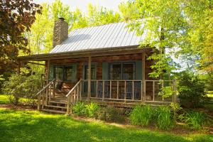 a log cabin with a porch and a chimney at Mountain Springs Cabins in Candler