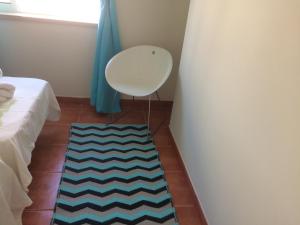 a room with a white chair and a blue curtain at Luxury Duplex with pool in Cabanas de Tavira