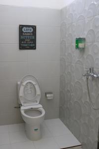 a bathroom with a toilet and a sign on the wall at dric's House in Tanjungpandan