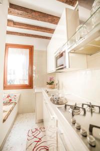 eine weiße Küche mit einem Waschbecken und einem Fenster in der Unterkunft Ca' Drio San Marco in Venedig