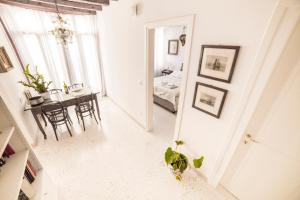 Ein weißes Zimmer mit einem Tisch und einem Schlafzimmer. in der Unterkunft Ca' Drio San Marco in Venedig