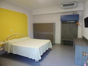 une salle d'hôpital avec un lit et un mur jaune dans l'établissement Camping Zeus, à Pompéi