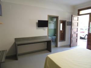 a room with a bed and a desk with a television at Camping Zeus in Pompei