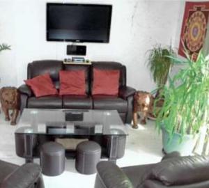 a living room with a leather couch and a table at Les Berges de l'Ô in Saint-Nicolas-de-Port