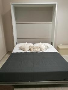 - un lit avec 2 couvertures et des oreillers dans l'établissement La Maison, à Margherita di Savoia
