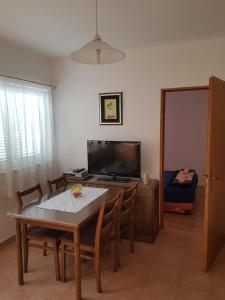 a living room with a table and a tv at Apartment Nera in Ledenice