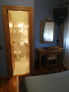 a bathroom with a toilet and a sink and a mirror at Hotel Xabier in Javier