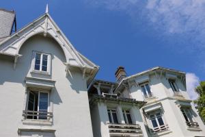 ein weißes Gebäude mit Fenstern und blauem Himmel in der Unterkunft Maison Valmer - L'armateur, élégant penthouse classé 4 étoiles in Le Havre