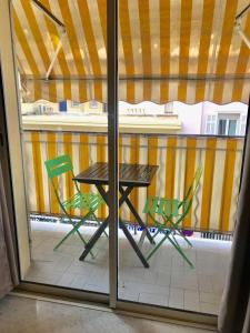 カンヌにある3 pièces- Vieux port- Terrasse - Parking Possibleの窓の外にテーブルと椅子2脚
