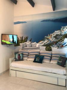 ポール・ルカートにあるBarcaresa-MAISONNETTE VUE MER PIEDS DANS L'EAU WIFIのソファ付きの客室で、壁にテレビが備わります。