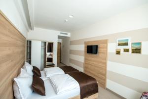 1 dormitorio con 1 cama y TV en la pared en Hotel Novitas Livno, en Livno