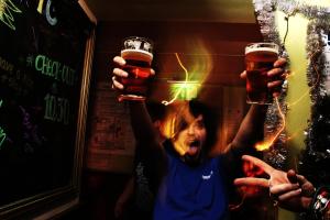 a little girl holding up two glasses of beer at Flying Pig Uptown in Amsterdam