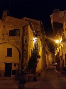 un callejón por la noche con un edificio y una calle en Casetta di San Martino, en Tarquinia