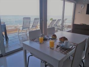 una mesa con comida y dos vasos de zumo de naranja en CMB Guesthouse, en Apúlia