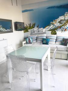 a dining room with a table and chairs and a couch at Barcaresa-MAISONNETTE VUE MER PIEDS DANS L'EAU WIFI in Port Leucate