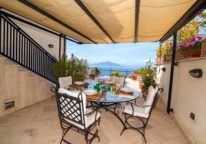 patio con mesa y sillas en el balcón en Una vedetta sul mare, en SantʼAgata sui Due Golfi
