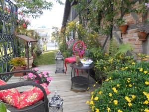 a patio with a table and chairs and flowers at La Petite France in Nova Petrópolis