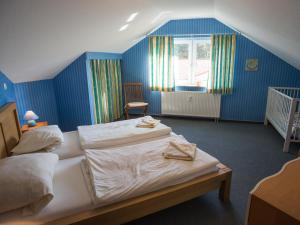 オストゼーバート・カールスハーゲンにあるAn der Pappelwendeの青いベッドルーム(ベッド2台、ベビーベッド1台付)