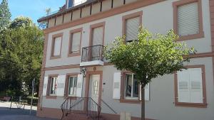 un edificio con un árbol delante de él en 1 rue des romains studio meublé clauss, en Niederbronn-les-Bains