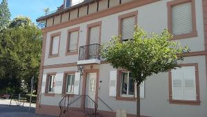 ein Gebäude mit einem Baum davor in der Unterkunft 1 rue des romains studio meublé clauss in Niederbronn-les-Bains
