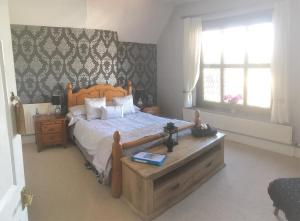 a bedroom with a bed with a wooden head board at Ty Mynydd Lodge in Cardiff