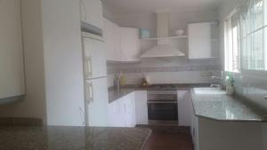 a kitchen with white cabinets and a sink and a window at Malvarrosa Calle Pavia in Valencia +11 photos