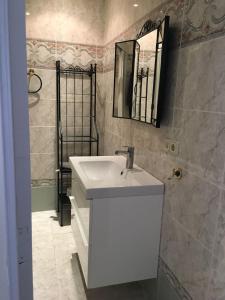 a bathroom with a white sink and a mirror at Malvarrosa Calle Pavia in Valencia
