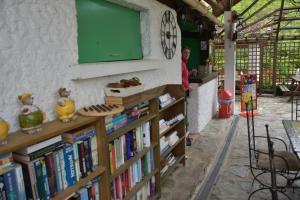 a man standing next to a book shelf filled with books at Camping des Drouilhèdes in Peyremale