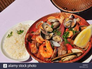 un plato de comida con marisco y arroz en una mesa en Alvor Navy Apartment, en Alvor