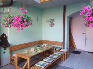 a table and benches in a room with flowers at Penzion Netolice in Netolice