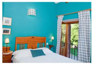 um quarto azul com uma cama e uma varanda em Molino De La Ferrería em Villacorta