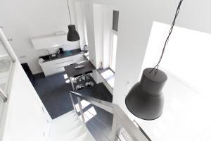 Vistas a la sala de estar y a la cocina con lámpara negra. en Mini Loft Design, en Budapest
