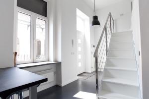 Una escalera en una habitación blanca con una mesa en Mini Loft Design, en Budapest