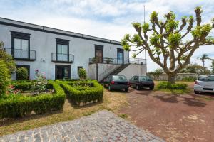 a white building with cars parked in front of it at Casa do Loreto in Ponta Delgada