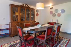 a dining room with a table and chairs and a cabinet at Casa do Loreto in Ponta Delgada +17 photos