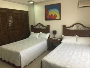 1 dormitorio con 2 camas y mesa con lámpara en Habitación Independiente en Santa Cruz de La Sierra en Hotel Casablanca, en Santa Cruz de la Sierra