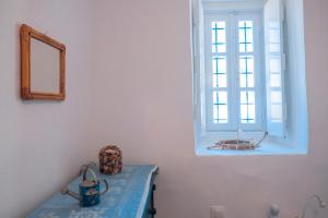 a room with a window and a table with a mirror at Lotus Sweet Home Hydra in Hydra