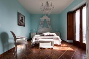 a bedroom with a bed and a chair and a chandelier at La Rossa Fantastica in Piedimonte dʼAlife