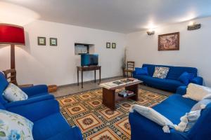 a living room with blue couches and a tv at Casa do Loreto in Ponta Delgada
