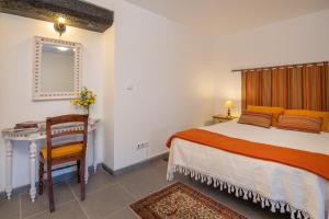 a bedroom with a bed and a desk and a chair at Casa do Loreto in Ponta Delgada