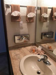 uma casa de banho com um lavatório e um espelho em Ixtapa Palace em Ixtapa