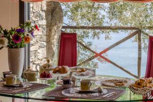Villa Degli Ulivi B&B في فينالي ليغوري: طاولة عليها طعام مطلة على المحيط