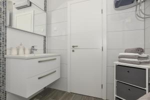 un bagno bianco con lavandino e specchio di Apartment Đaninovica I a Makarska Altre 18 foto