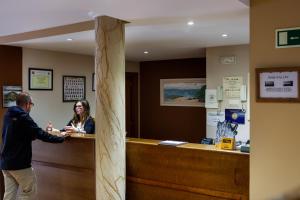 a man shaking hands with a woman at a counter at Hotel Rincón de Antón in Abanillas