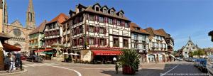 a large building on a street in a city at Hôtel De La Cloche in Obernai