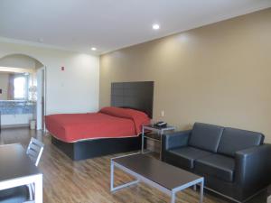 a bedroom with a bed and a couch and a table at Palace Inn Westheimer in Houston