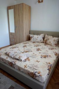 een slaapkamer met een bed en een houten deur bij La Alina in Eforie Sud