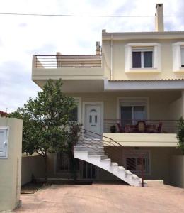 a house with a white staircase in front of it at Amazing House in Kiato near the Beach in Kiáton